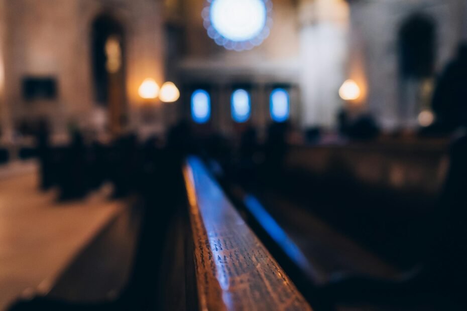 Detailed view of a beautifully lit church interior, highlighting wooden benches and architectural arches.